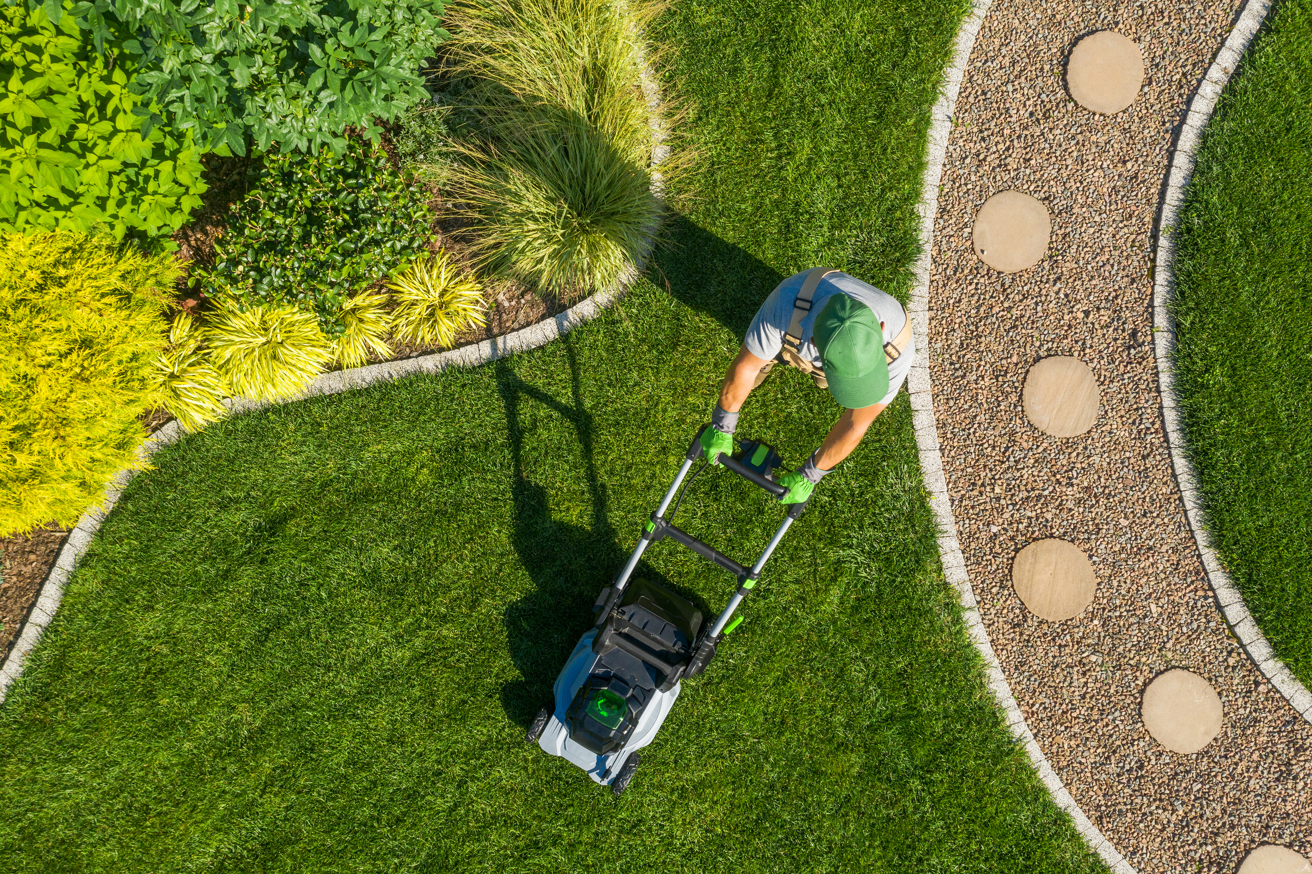 Aerial view of lawn care professional mowing a perfectly maintained New Orleans yard
